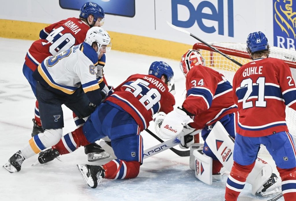 St. Louis Blues' Jake Neighbours (63) moves in to score Montreal Canadiens goaltender Jake Allen as Canadiens' David Savard (58) Joel Armia (40) and Kaiden Guhle defend during third period NHL hockey action in Montreal, Sunday, Feb. 11, 2024. THE CANADIAN PRESS/Graham Hughes