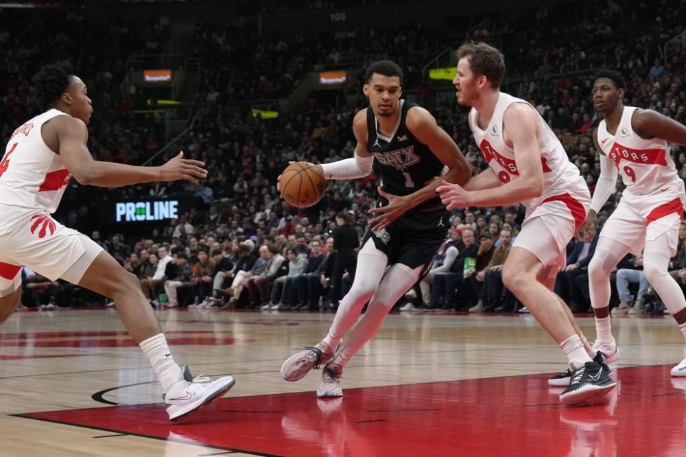 San Antonio Spurs centre Victor Wembanyama (1) drives towards the basket as Toronto Raptors' Jakob Poeltl (19) defends during first half NBA basketball action in Toronto on Monday Feb. 12, 2024. THE CANADIAN PRESS/Chris Young