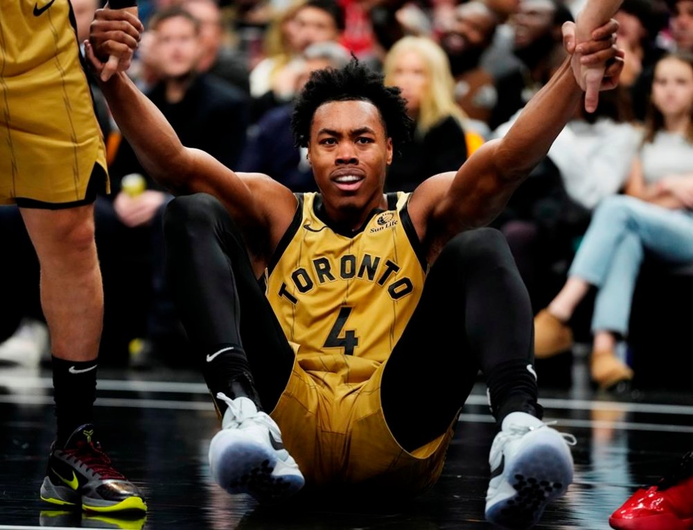 Toronto Raptors' Scottie Barnes (4) is helped up off the court by teammates during second half NBA basketball action against the Chicago Bulls in Toronto on Friday, November 24, 2023. THE CANADIAN PRESS/Frank Gunn