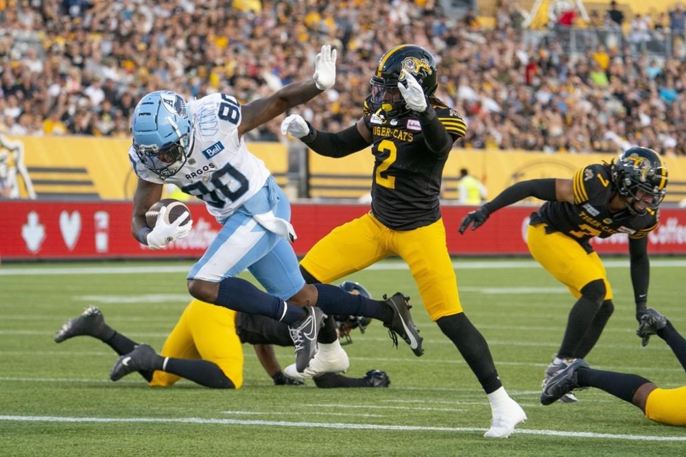 Toronto Argonauts wide receiver DaVaris Daniels (80) gets into the endzone for a touchdown as Hamilton Tiger-Cats defensive back Tunde Adeleke (2) defends during first half CFL football game action in Hamilton, Ont. on Friday, July 21, 2023. The Toronto Argonauts signed Adeleke and linebacker Fraser Sopik on Tuesday, the opening day of CFL free agency. THE CANADIAN PRESS/Peter Power