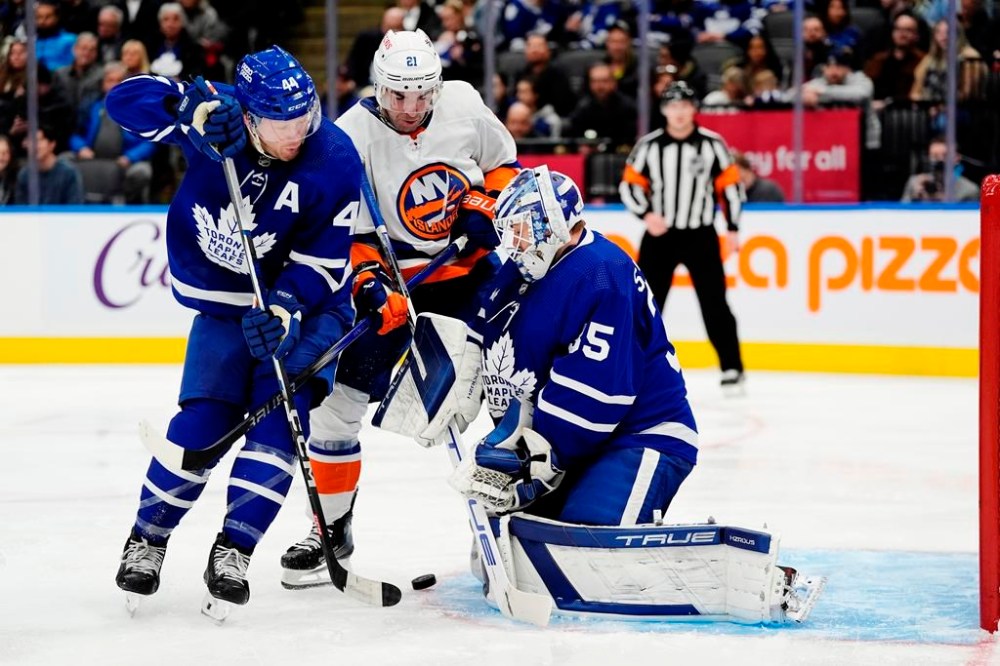 Toronto Maple Leafs' goaltender Ilya Samsonov (35) makes a save as Morgan Rielly (44) and New York Islanders' Kyle Palmieri (21) look for the rebound during third period NHL hockey action in Toronto on Monday, February 5, 2024.THE CANADIAN PRESS/Frank Gunn
