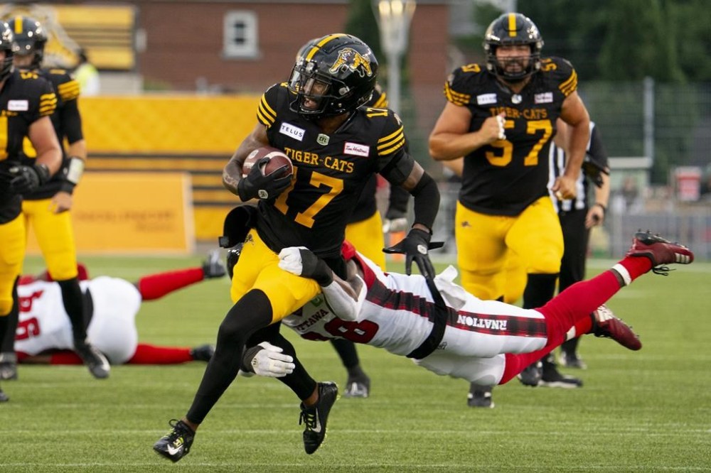 Hamilton Tiger-Cats wide receiver Terry Godwin II (17) is tackled by Ottawa Redblacks linebacker Frankie Griffin (28) during first-half CFL action in Hamilton, Ont. on Saturday, July 8, 2023. The Hamilton Tiger-Cats re-signed Godwin II on Tuesday. THE CANADIAN PRESS/Peter Power