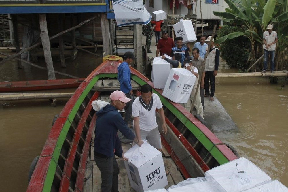Electoral workers unload ballot boxes from a boat during the distribution of election paraphernalia to remote villages, in Pemulutan, South Sumatra, Indonesia, Tuesday, Feb. 13, 2024. Indonesia, the world's third-largest democracy, will open its polls on Wednesday, Feb. 14, to nearly 205 million eligible voters in presidential and legislative elections, the fifth since Southeast Asia's largest economy began democratic reforms in 1998. (AP Photo/Muhammad Hatta)