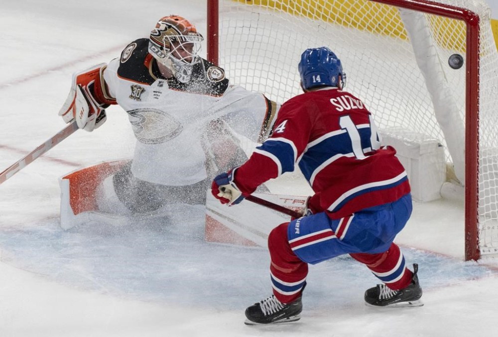 Montreal Canadiens' Nick Suzuki (14) scores on Anaheim Ducks goaltender Lukas Dostal (1) during second period NHL hockey action in Montreal on Tuesday, Feb. 13, 2024. THE CANADIAN PRESS/Christinne Muschi