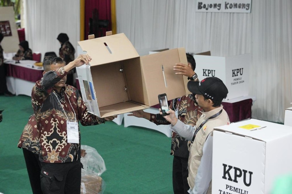 Electoral workers show an empty ballot box as the polling station opens during the election in Jakarta, Indonesia, Wednesday, Feb. 14, 2024. Millions of Indonesians were choosing a new president Wednesday as the world's third-largest democracy aspires to become a global economic powerhouse just over 25 years since emerging from a brutal authoritarian era. (AP Photo/Vincent Thian)