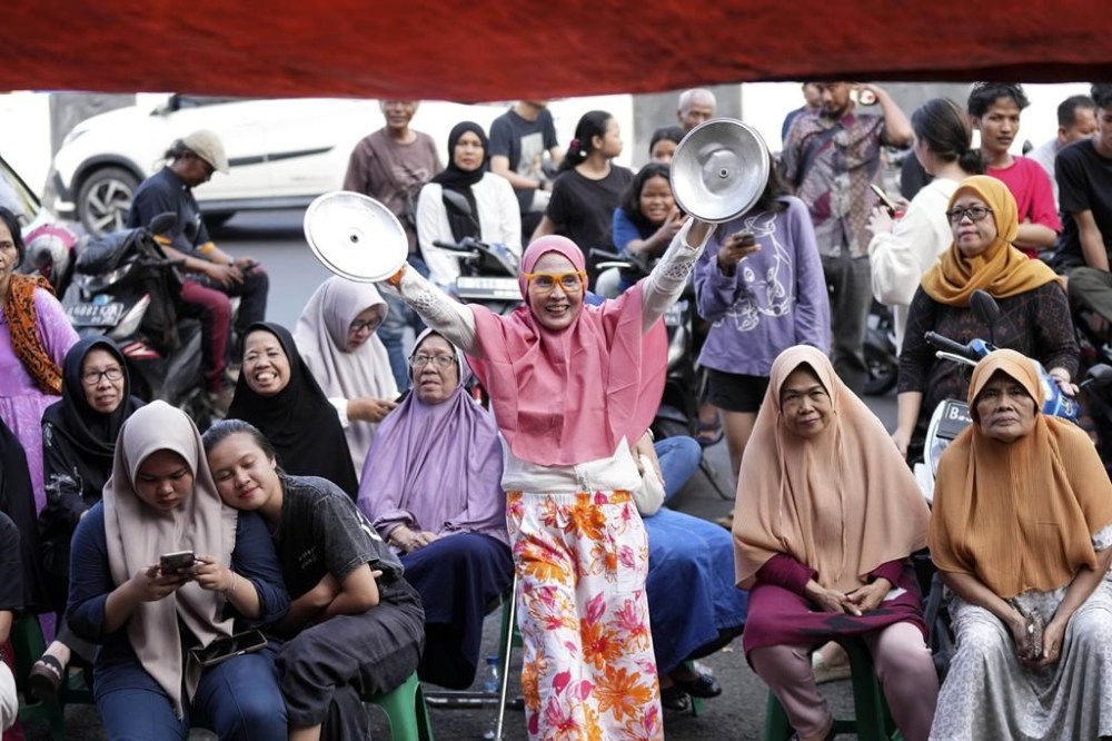 A woman cheers during the vote counting at a polling station following the election in Jakarta, Indonesia, Wednesday, Feb. 14, 2024. Indonesian voters were choosing a new president Wednesday as the world's third-largest democracy aspires to become a global economic powerhouse a quarter-century after shaking off a brutal dictatorship. (AP Photo/Tatan Syuflana)
