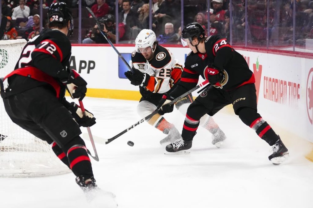 Ottawa Senators defenceman Jacob Bernard-Docker (24) gets pushed off the puck by Anaheim Ducks centre Mason McTavish (23) during first period NHL hockey action in Ottawa on Thursday, Feb. 15, 2024. THE CANADIAN PRESS/Sean Kilpatrick