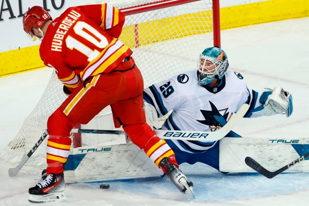 San Jose Sharks goalie Mackenzie Blackwood makes a save against Calgary Flames' Jonathan Huberdeau during first period NHL hockey action in Calgary, Thursday, Feb. 15, 2024. THE CANADIAN PRESS/Larry MacDougal
