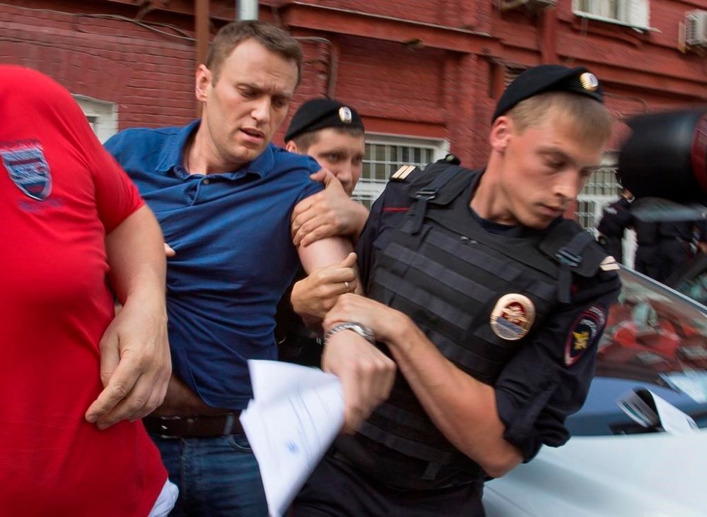 FILE - Police officers detain Russian opposition leader Alexei Navalny, left, in Moscow on July 10, 2013. Russia’s prison agency says that imprisoned opposition leader Alexei Navalny has died. He was 47. The Federal Prison Service said in a statement that Navalny felt unwell after a walk on Friday Feb. 16, 2024 and lost consciousness. (AP Photo/Alexander Zemlianichenko, File)
