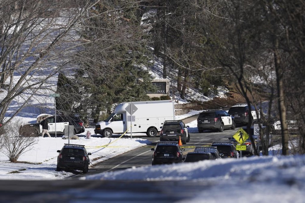 Law enforcement vehicles are parked near the scene where two police officers and a first responder were shot and killed Sunday, Feb. 18, 2024, in Burnsville, Minn. (AP Photo/Abbie Parr)