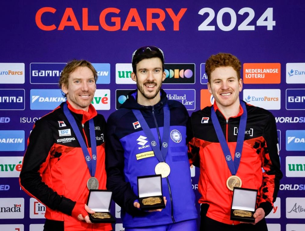 Italy's Davide Ghiotto, centre, celebrates his victory with second place finisher Canada's Ted-Jan Bloemen, left, and third place finisher Canada's Graeme Fish on the podium following the men's 10000-metre event at the ISU World Speed Skating Championships in Calgary, Alta., Sunday, Feb. 18, 2024.THE CANADIAN PRESS/Jeff McIntosh
