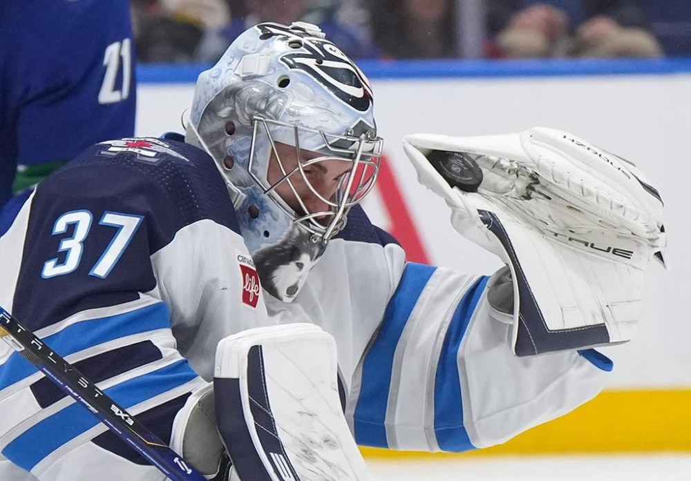 Winnipeg Jets goaltender Connor Hellebuyck makes a glove save during the third period of an NHL hockey game against the Vancouver Canucks in Vancouver, on Saturday, Feb. 17, 2024. THE CANADIAN PRESS/Darryl Dyck