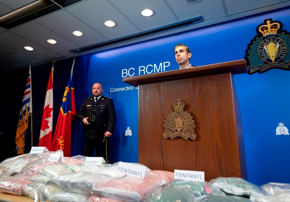Chief Superintendent David Teboul, left, of the BC-RCMP federal Policing program, and Cpl. Arash Seyed, listen to a question from a reporter during a press conference at BC RCMP Divisional Headquarters in Surrey, B.C., Friday, Feb. 23, 2024. In a joint investigation, the BC-RCMP federal Policing program and the Integrated Homicide Investigation Team have recently charged eight members of a B.C.-based criminal organization with numerous drug and weapon related charges. THE CANADIAN PRESS/Tijana Martin