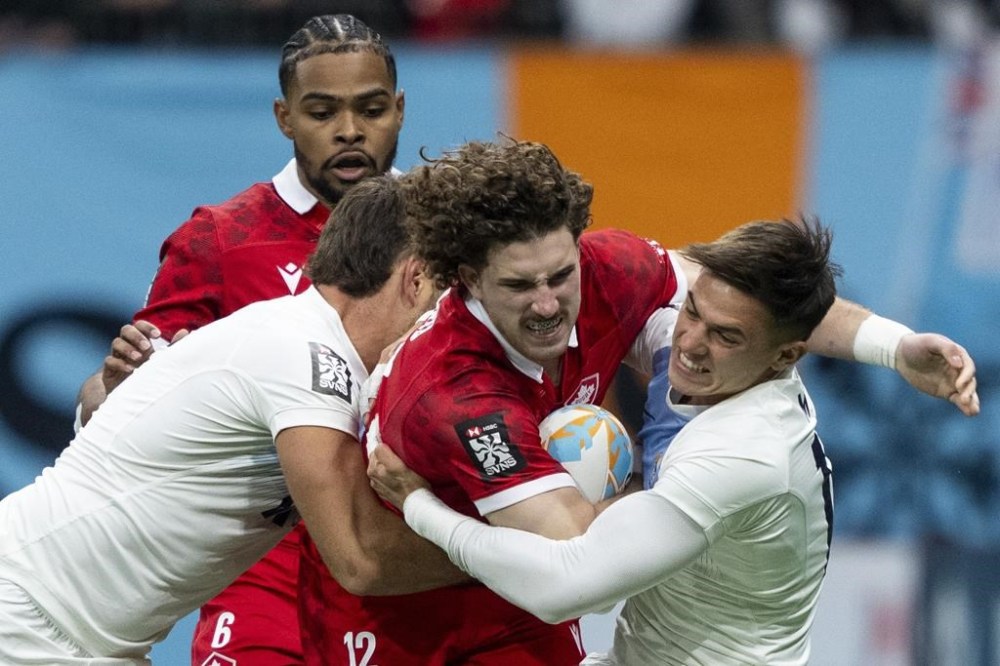 Argentina's Santiago Alvarez, left, and Marcos Moneta, right, tackle Canada's David Richard as Josiah Morra watches from behind during Vancouver Sevens rugby action, in Vancouver, on Friday, Feb. 23, 2024. THE CANADIAN PRESS/Ethan Cairns