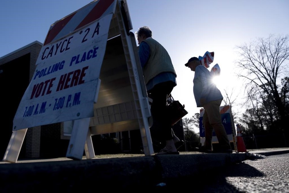Residents walk into their voting precinct after voting on the morning of the South Carolina Republican primary at New Bridge Academy in Cayce, S.C., Saturday, Feb. 24, 2024. (AP Photo/Andrew Harnik)