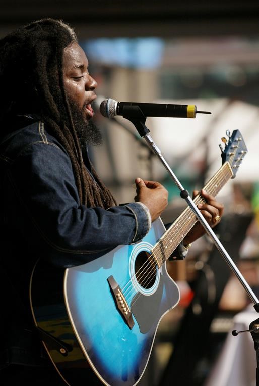 FILE - Reggae singer Peter Anthony Morgan of Morgan Heritage performs on the at the New Orleans Jazz and Heritage festival Saturday, May 4, 2002, in New Orleans. Peter Morgan, lead singer of the popular reggae band Morgan Heritage that he founded with five siblings, died Sunday, Feb. 25, 2024, at age 46, his family announced. Morgan, known as “Peetah,” was a son of renowned Jamaican reggae singer Denroy Morgan. (AP Photo/Douglas Mason, File)