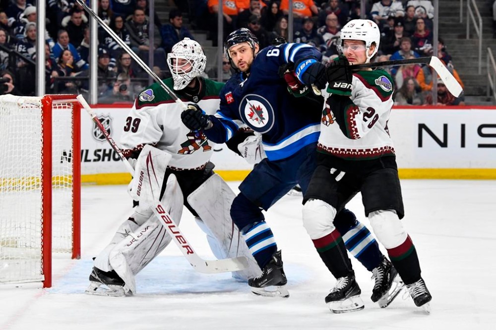 Arizona Coyotes' Barrett Hayton (29) defends against Winnipeg Jets' Nino Niederreiter (62) in front of his goaltender Connor Ingram (39) during second period NHL action in Winnipeg on Sunday Feb. 25, 2024. THE CANADIAN PRESS/Fred Greenslade