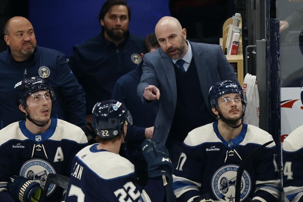 Columbus Blue Jackets coach Pascal Vincent, top right, talks with Blue Jackets defenseman Jake Bean (22) during the third period of an NHL hockey game against the New York Rangers in Columbus, Ohio, Sunday, Feb. 25, 2024. (AP Photo/Paul Vernon)