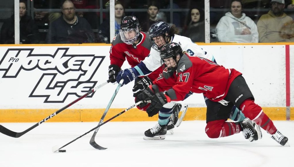 Ottawa's Gabbie Hughes (17) and Hayley Scamurra (14) fight for the puck against New York's Alexandra Labelle (13) during second period PWHL hockey action in Ottawa on Wednesday, Feb. 28, 2024. THE CANADIAN PRESS/Sean Kilpatrick
