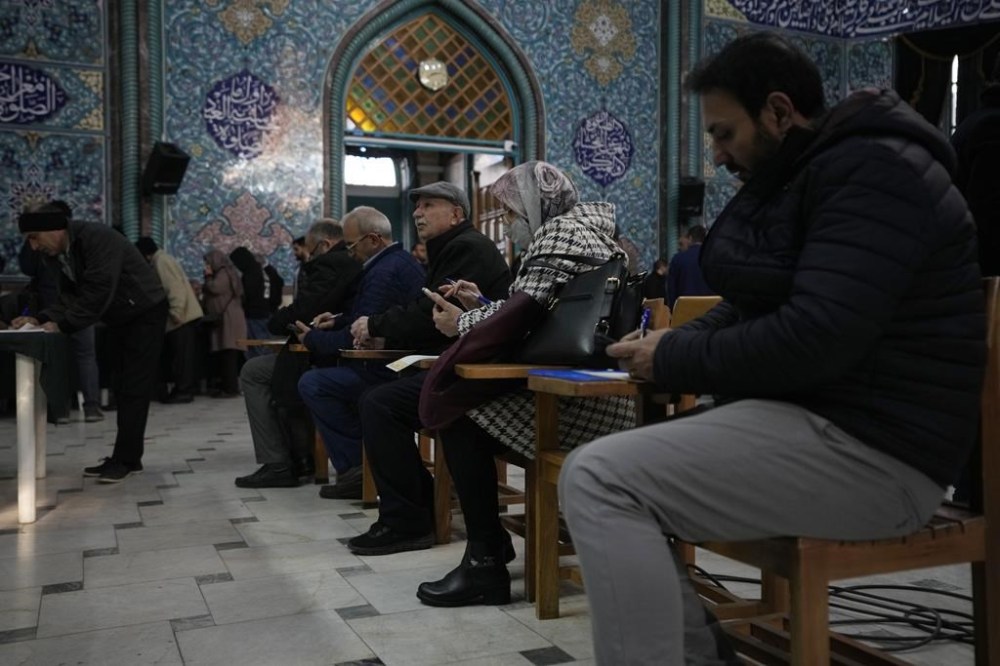 Voters fill out their ballots in the parliamentary and Assembly of Experts elections at a polling station in Tehran, Iran, Friday, March 1, 2024. Iran began voting Friday in its first elections since the mass 2022 protests over its mandatory hijab laws after the death of Mahsa Amini, with questions looming over just how many people will turn out for the poll. (AP Photo/Vahid Salemi)
