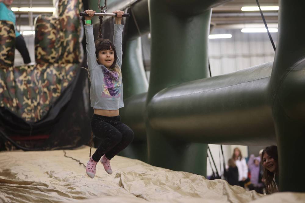 Ivy Goossen, 8, enjoys a ride on the mobile zipline at the Family Fun Day on Saturday. (Abiola Odutola/The Brandon Sun)