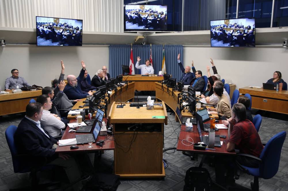 Members of Brandon City Council raise their hands late Saturday afternoon to approve a budget requiring a 9.4 per cent property tax increase. All but two councillors voted in favour of the final budget. (Colin Slark/The Brandon Sun)