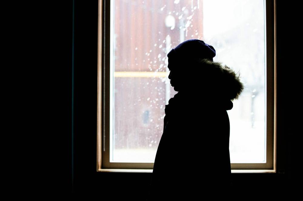 Annour, a 28-year-old refugee who journeyed to Canada across many countries from N’Djamena, Chad, stands by a window at the Salvation Army in Winnipeg on Wednesday. (Mikaela MacKenzie/Winnipeg Free Press)