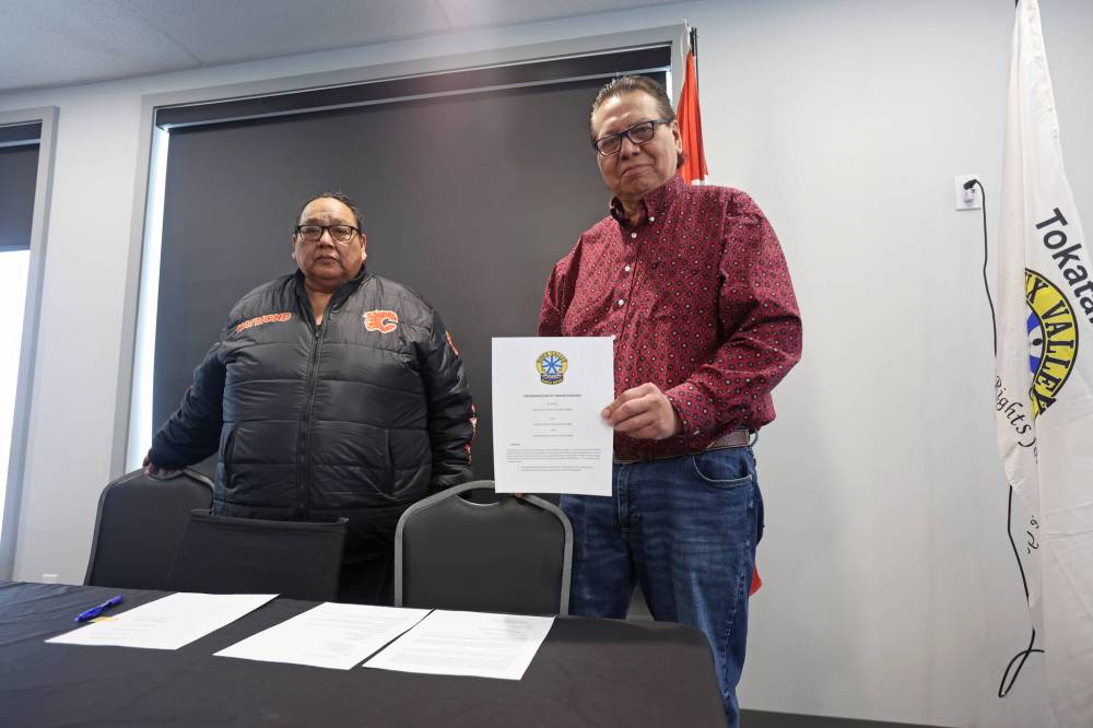 Sioux Valley Dakota Nation Chief Vince Tacan holds up a memorandum of understanding, signed by Tacan, Canupawakpa Dakota Nation Chief Raymond Brown (left) and Dakota Plains First Nation Chief Don Smoke, who joined the meeting via video-link, to work together to build a casino along the Trans-Canada Highway at Highway 21 south of Sioux Valley Dakota Nation. (Tim Smith/The Brandon Sun)