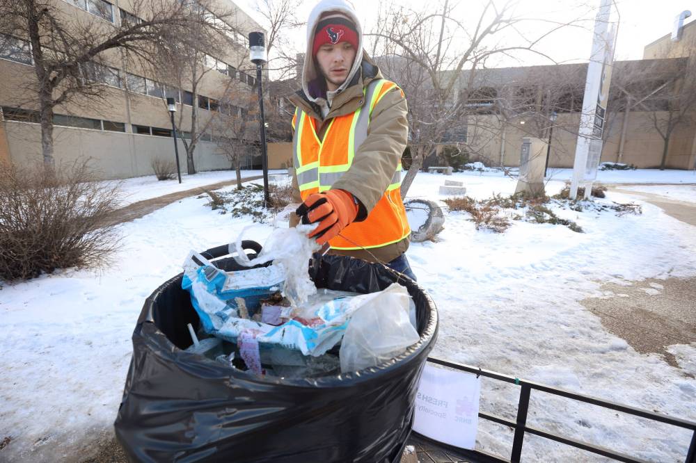 Julian McKay with the BNRC Fresh Start Specialty Cleaning Service cleans up litter from along Rosser Avenue in Brandon on Monday. (Tim Smith/The Brandon Sun)