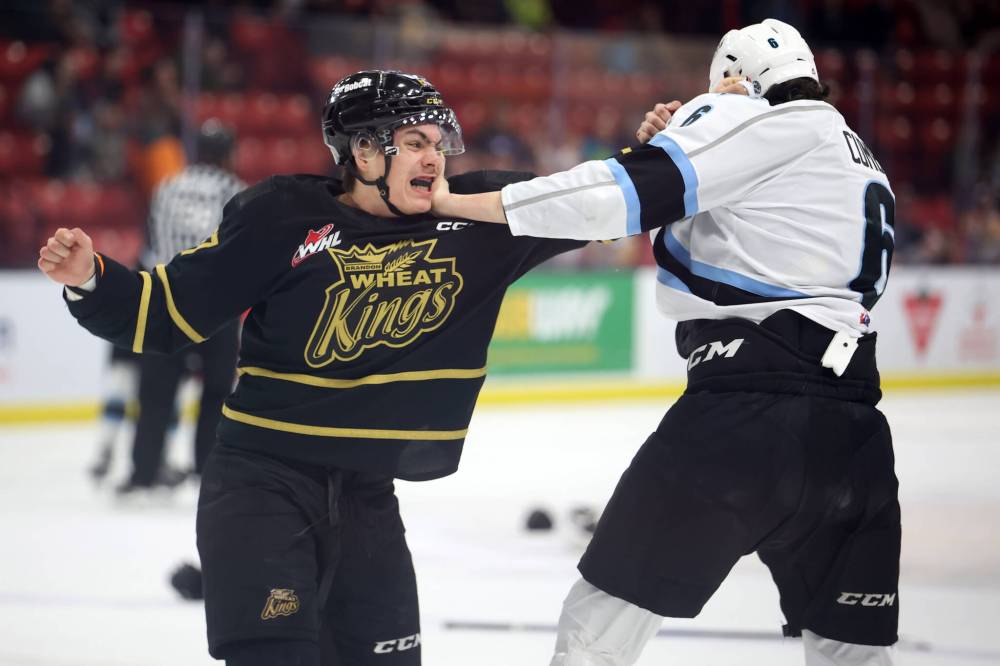 Brandon Wheat Kings forward Matthew Henry, in black, fires a punch at Winnipeg Ice defenceman Ashton Cumby last season at Westoba Place. Henry’s role as an enforcer is virtually gone from the Western Hockey League, but the Prince Albert product has been protecting his Brandon teammates for two seasons. (Tim Smith/The Brandon Sun)