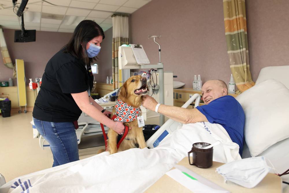 Brandi Morton and pup Murphy visit with Steve Yaroway in the hospital's dialysis centre on Wednesday evening.