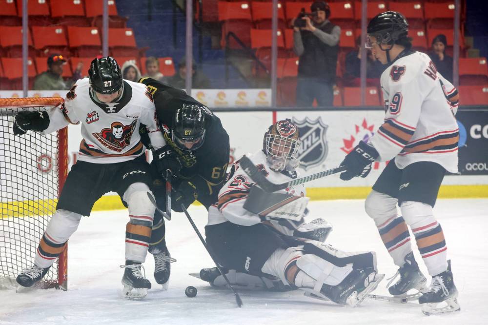 Brandon Wheat Kings forward Matt Henry (67) digs for the puck between Calgary Hitmen defenceman Fraser Leonard (27) and goalie Ethan Buenaventura (29) during first period WHL action at Westoba Place Friday night. (Tim Smith/The Brandon Sun)