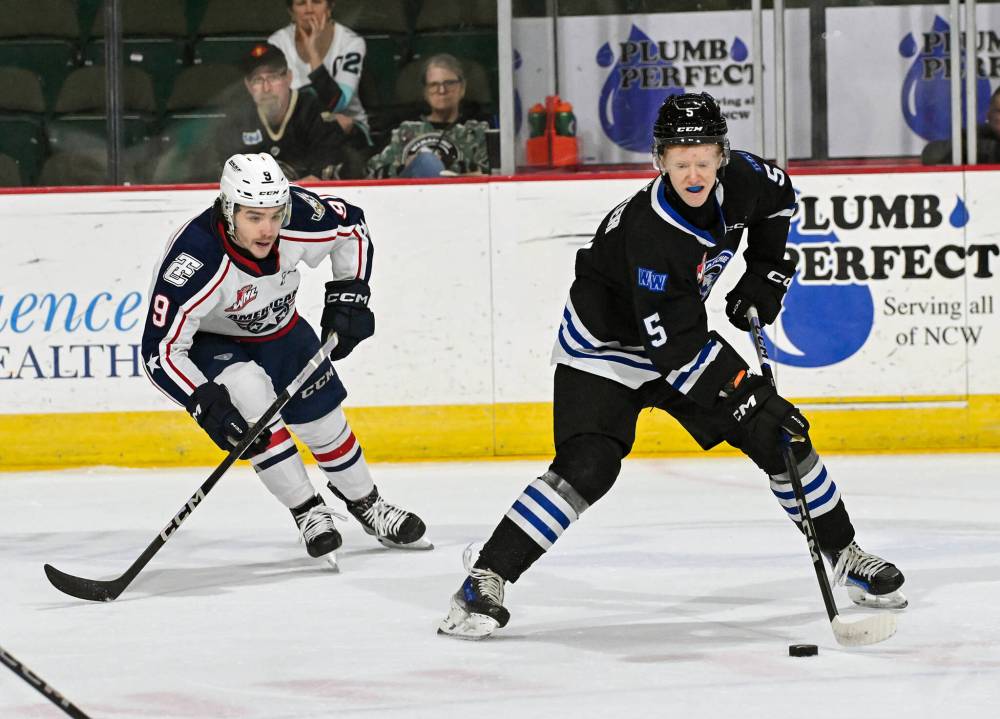 Wenatchee Wild defenceman Josh Fluker of Boissevain carries the puck as he is shadowed by Tri-City Americans forward Drew Freer during a recent game. (Russ Alman/Wenatchee Wild)