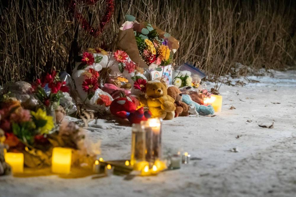 A memorial is set up during a candlelight vigil for Amanda Clearwater, 30, her children — Bethany, 6, Jayven, 4, Isabella, two months — and her niece Myah-Lee Gratton, 17, in Carman last week. (Brook Jones/Winnipeg Free Press)