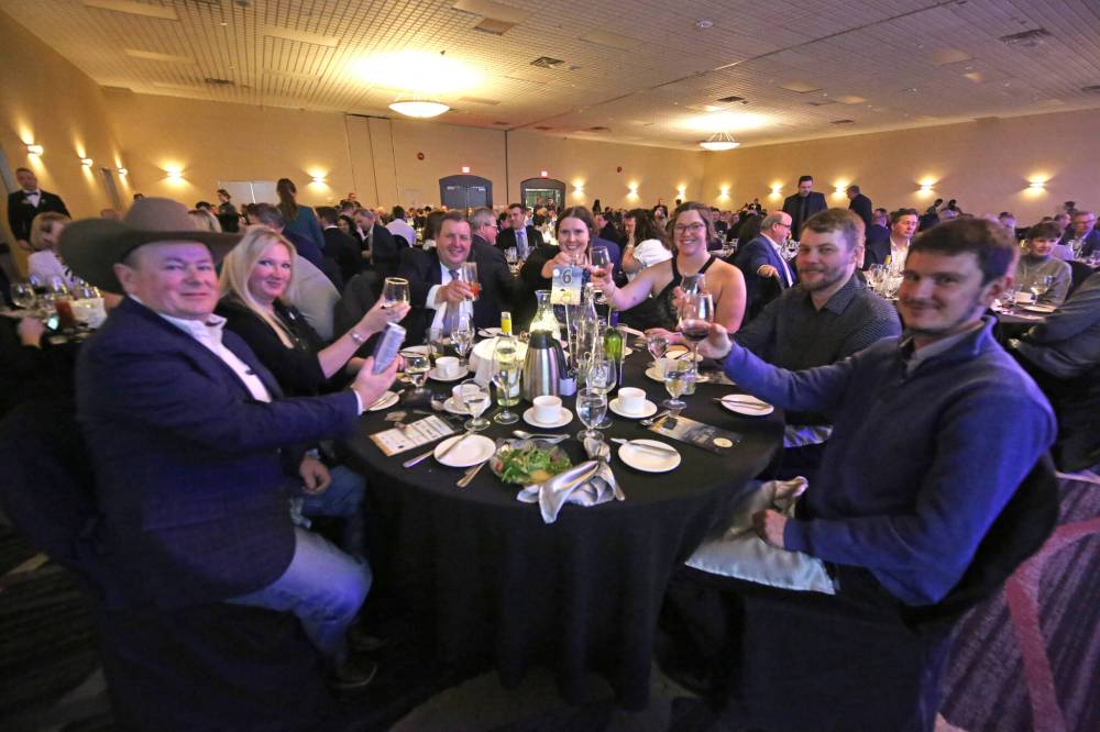 Provincial Exhibition of Manitoba general manager Mark Humphries (third from left) sits with members of his family, along with Heartland Livestock Services auctioneer Ward Culter (far left) and his wife, during the Provincial Exhibition of Manitoba's annual President's Dinner on Thursday evening at the Victoria Inn.