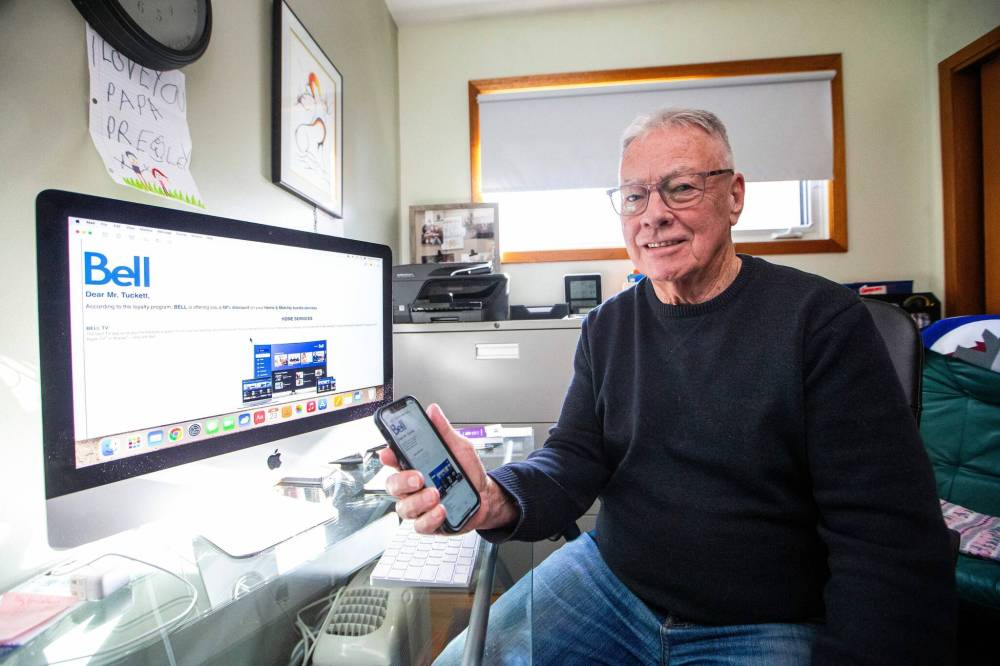 Former provincial ombudsman Barry Tuckett, who was surprised to find both his and his wife’s cellphone services cancelled while playing with phone scammers, poses Friday with the original email he was sent. (Mikaela MacKenzie/Winnipeg Free Press)