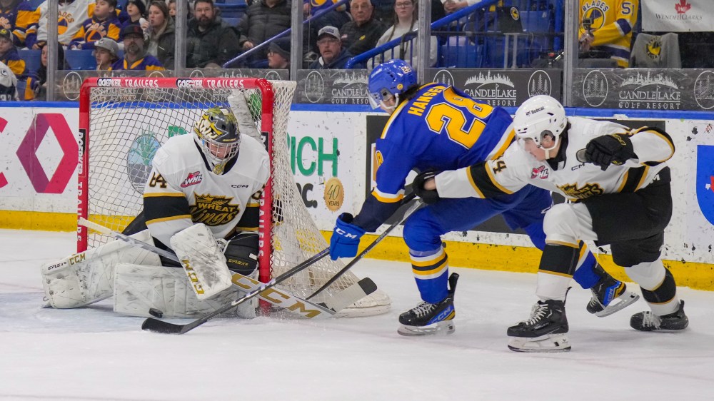 Brandon Wheat Kings goalie Carson Bjarnason (64) makes a save on Saskatoon Blades forward Lukas Hansen (28) as he goes to the net under the watchful eye of defencemen Andrei Maliavan (44) at SaskTel Centre on Sunday afternoon. The Blades won 3-1. (Steve Hiscock/Saskatoon Blades)