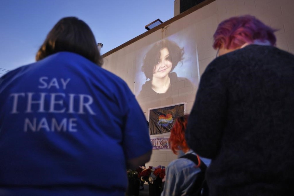 FILE - A photograph of Nex Benedict, who died a day after a fight in a high school bathroom, is projected during a candlelight service at Point A Gallery, Feb. 24, 2024, in Oklahoma City. The death of a nonbinary Oklahoma high school student who died the day after a fight inside a high school restroom has been ruled a suicide by the state medical examiner's office. A summary autopsy report released on Wednesday, March 13, 2024 determined that Nex Benedict had toxic levels of two drugs in their system. (Nate Billings/The Oklahoman via AP, File)