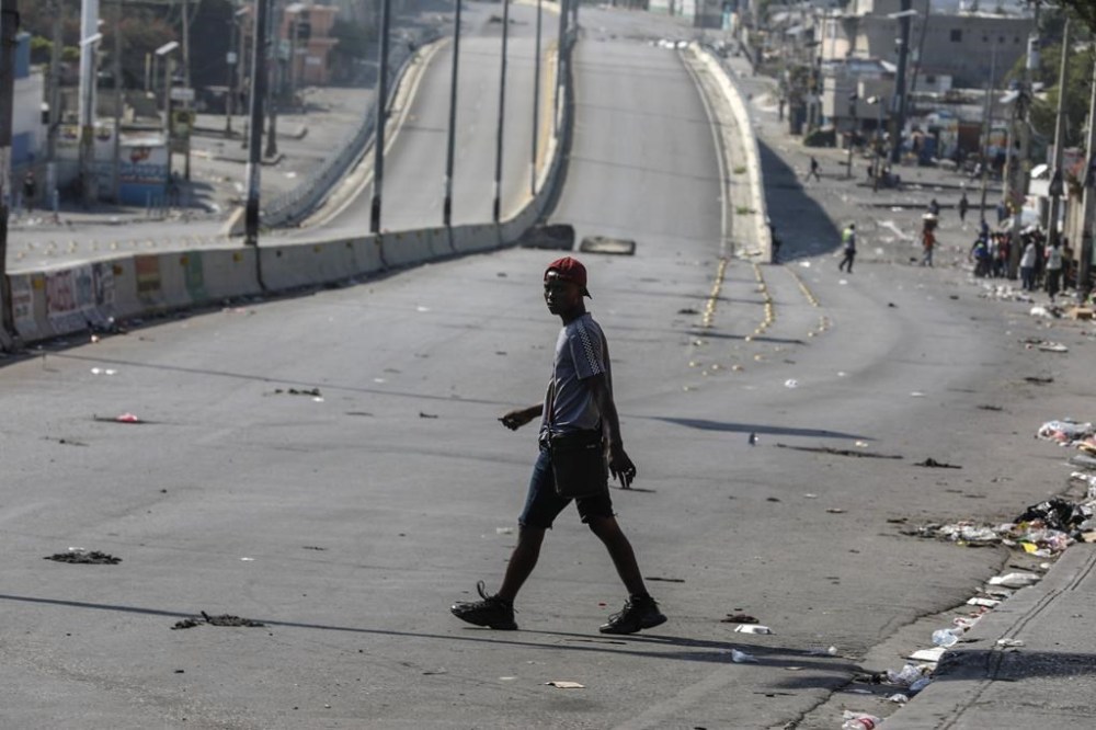 A pedestrian crosses a street free of traffic in Port-au-Prince, Haiti, Wednesday, March 13, 2024. THE CANADIAN PRESS/AP, Odelyn Joseph