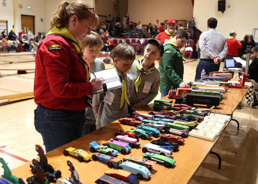 Leah Foster, commissioner for the Brandon Scout Group goes over the entries while competitors look on during the Kubkar Regional Rally held at École New Era School gym on Saturday. Prizes were awarded for the fastest as well as best design.