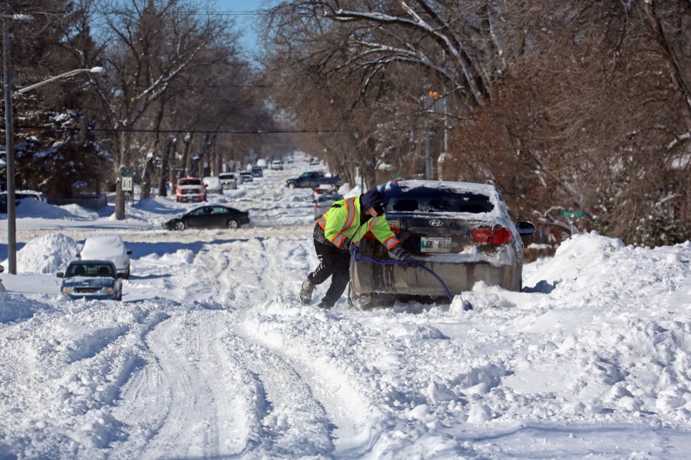 A man attempts to free his car from the snow on one of the many snow-covered city streets in Brandon on Monday afternoon, following a weekend blizzard that Environment Canada says dumped nearly 30 cm of snow on the city. (Matt Goerzen/The Brandon Sun)