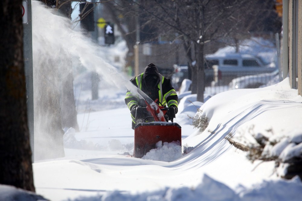 A man with a snowblower cleans the sidewalk along 10th Street, north of Victoria Avenue on Monday morning. (Matt Goerzen/The Brandon Sun)