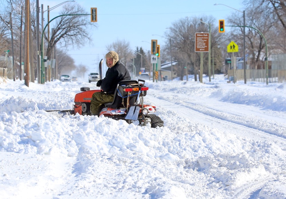 A Brandon homeowner along Victoria Avenue opposite the Brandon Regional Health Centre operates a garden tractor snowplow in his front entrance on Monday afternoon, following a weekend blizzard that dumped nearly 30 cm of snow on the city. (Matt Goerzen/The Brandon Sun)