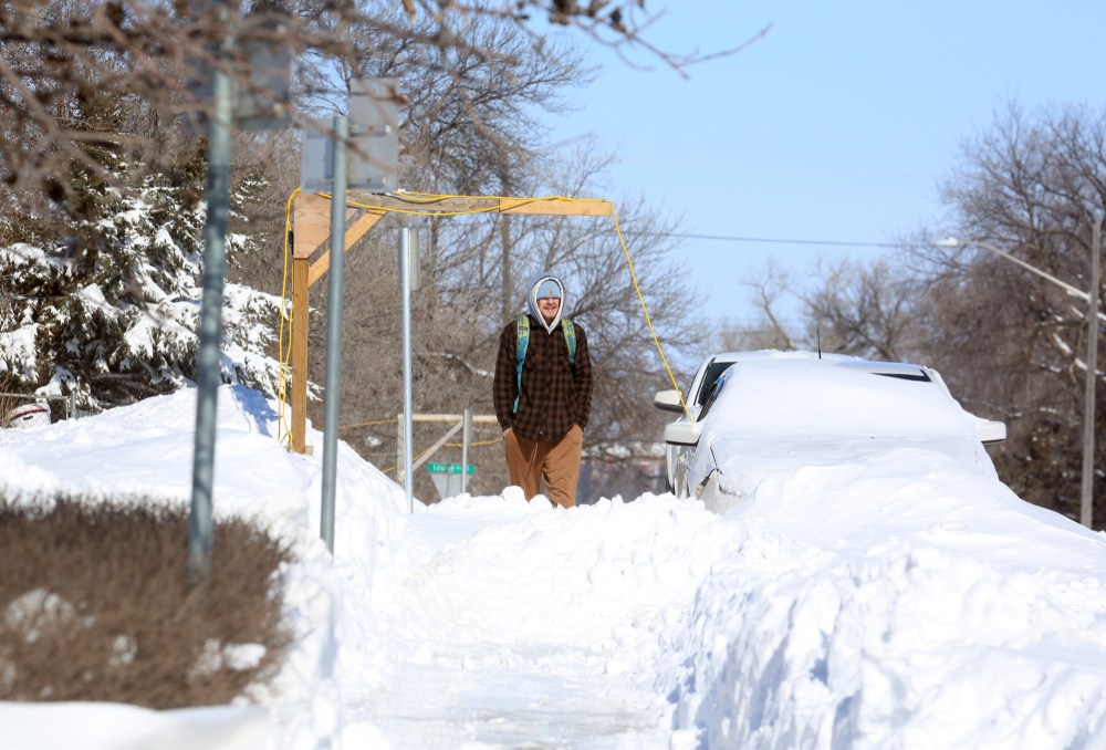 A pedestrian walks a snowpacked sidewalk along Dennis Street on Monday afternoon. (Matt Goerzen/The Brandon Sun)