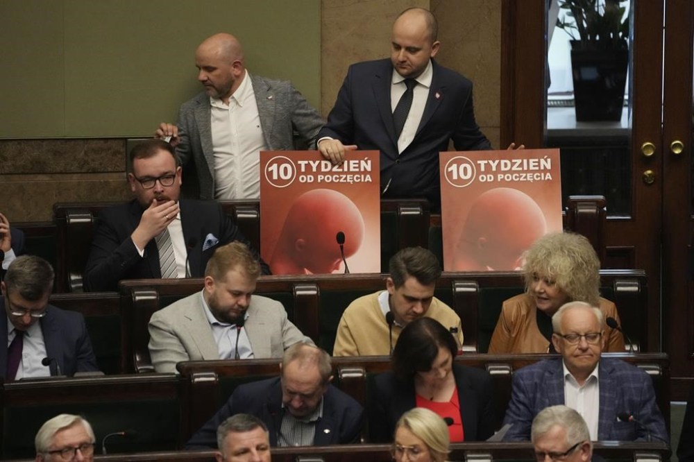 Dariusz Matecki, top right, a conservative lawmaker in the Polish parliament, displays a poster showing a fetus and the words