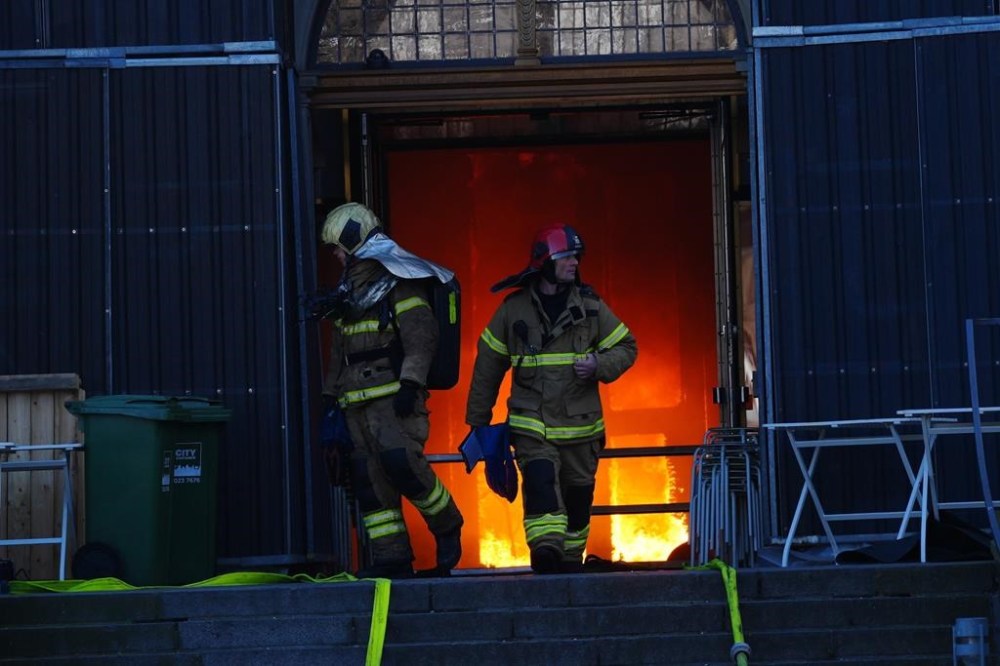 Firefighters walk out of the main entrance as the Old Stock Exchange burns in Copenhagen, Denmark, Tuesday, April 16, 2024. One of Copenhagen’s oldest buildings is on fire and its iconic spire has collapsed. The roof of the 17th-century old Stock Exchange, or Boersen, that was once Denmark’s financial center, was engulfed in flames Tuesday. (Ida Marie Odgaard/Ritzau Scanpix via AP)