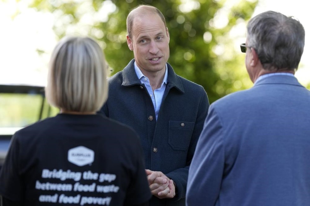 Britain's Prince William is greeted as he arrives for a visit to Surplus to Supper, in Sunbury-on-Thames, Surrey, England, Thursday, April 18, 2024. The Prince visited Surplus to Supper, a surplus food redistribution charity, to learn about its work bridging the gap between food waste and food poverty across Surrey and West London. (AP Photo/Alastair Grant, pool)