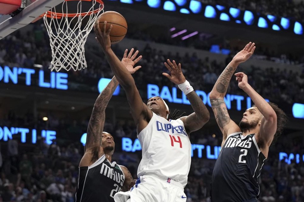 Los Angeles Clippers guard Terance Mann (14) drives to the basket past Dallas Mavericks forward P.J. Washington , left, and center Dereck Lively II (2) during the first half of Game 4 of an NBA basketball first-round playoff series Sunday, April 28, 2024, in Dallas. (AP Photo/Jeffrey McWhorter)