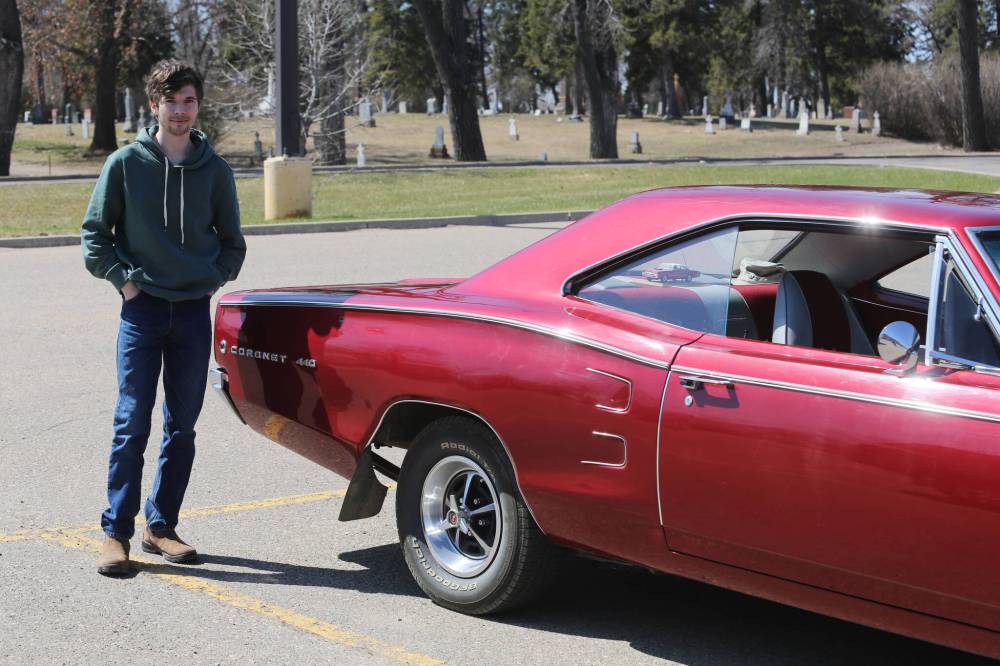 Nate Buhler stands next to the 1968 Dodge Coronet 440 that his grandfather restored.