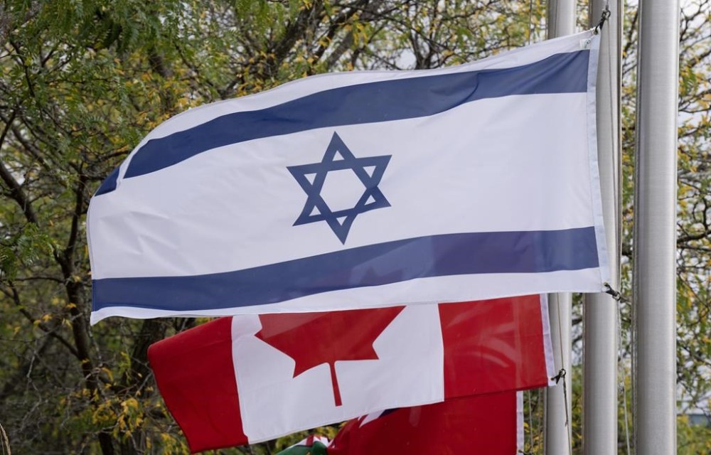The flags of Canada and Israel fly at half mast at a community building on Wednesday, Oct. 11, 2023 in Ottawa. Ottawa city officials say Israel's flag will be raised tomorrow in a private event to mark the country's establishment. THE CANADIAN PRESS/Adrian Wyld